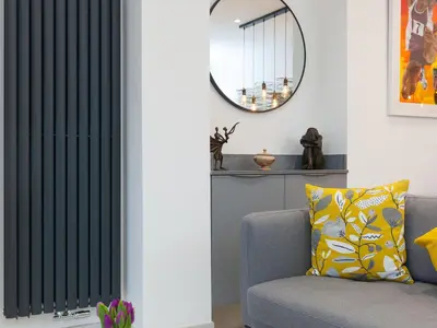 a living room with a black vertical blind in front of a couch at Avon Cottage in St Ives