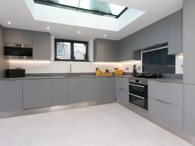 a kitchen with white cabinets and a skylight at Avon Cottage in St Ives