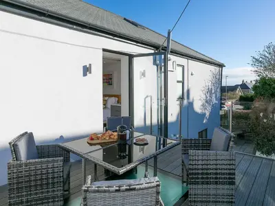 a patio with a table and chairs on a deck at Avon Cottage in St Ives