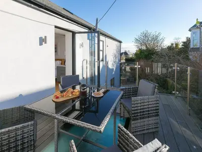 a balcony with a table and chairs on a deck at Avon Cottage in St Ives