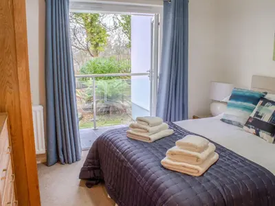 a bedroom with two towels on a bed with a window at Sea Bleu in St Ives