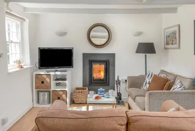 a living room with a couch and a fire place at Castle Cottage, Port Isaac Bay Holidays in Port Isaac