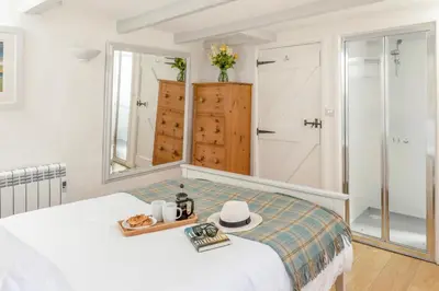 a bedroom with a bed and a mirror at Castle Cottage, Port Isaac Bay Holidays in Port Isaac