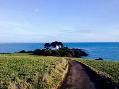 a house on a hill next to the ocean at The Coach House in Par