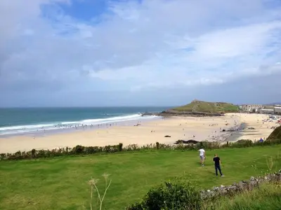 two people standing on a hill near a beach at The Coach House in Par