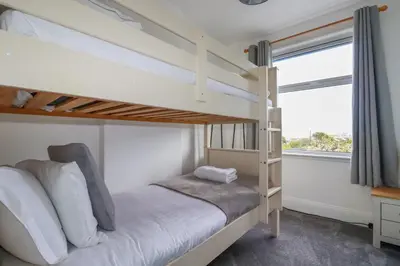 a bedroom with a bunk bed and a window at 119 Henver Road in Newquay