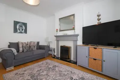 a living room with a couch and a flat screen tv at 119 Henver Road in Newquay