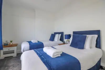 two beds in a room with blue and white at 119 Henver Road in Newquay