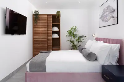 a bedroom with a white bed and a tv at Brand new, Gwithian lodge, eco home in Praze an Beeble