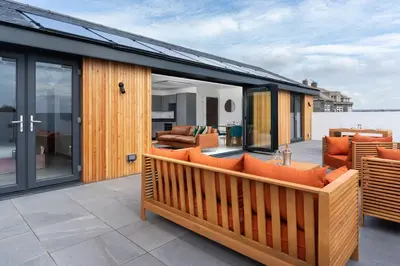 an open deck with orange furniture on a house at Brand new, Gwithian lodge, eco home in Praze an Beeble