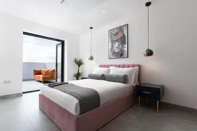 a bedroom with a king sized bed and a balcony at Brand new, Gwithian lodge, eco home in Praze an Beeble