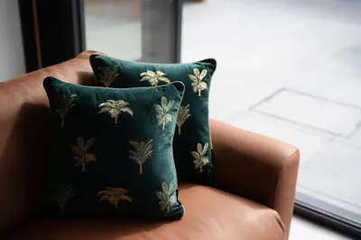 a green pillow sitting on a brown chair at Brand new, Gwithian lodge, eco home in Praze an Beeble