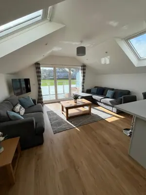a living room with couches and a table at The Boathouse in Mylor Bridge