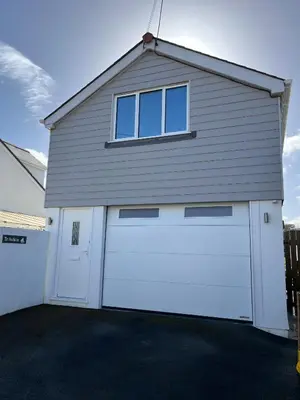 a garage with two doors and a window at The Boathouse in Mylor Bridge