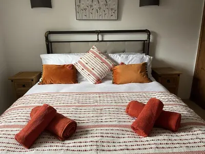 a bed with four pillows on top of it at Stunning 4 Bed Pet Friendly Cottage with Hot Tub in Bodmin