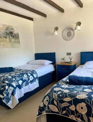 two beds in a room with blue and white at Stunning 4 Bed Pet Friendly Cottage with Hot Tub in Bodmin