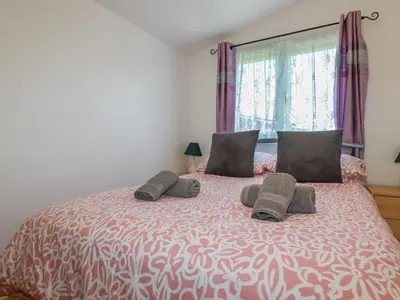 a bedroom with a large bed with two pillows at Cornish Holiday at Atlantic Bays in St Merryn