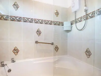 a bathroom with a tub and a shower stall at Cornish Holiday at Atlantic Bays in St Merryn