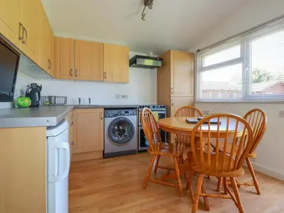 a kitchen with a table and chairs in a kitchen at Cornish Holiday at Atlantic Bays in St Merryn