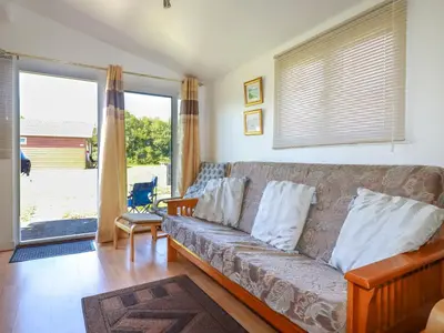 a living room with a couch and a large window at Cornish Holiday at Atlantic Bays in St Merryn