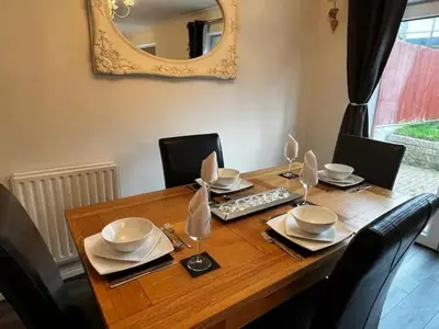 a dining room table with chairs and a mirror at Cornish Highbury in Hayle