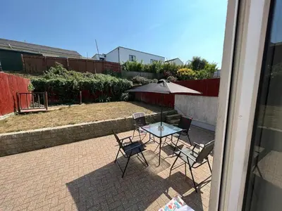 a patio with a table and chairs and an umbrella at Cornish Highbury in Hayle