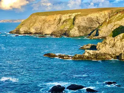 a large body of water with rocks in the ocean at Cornish Highbury in Hayle