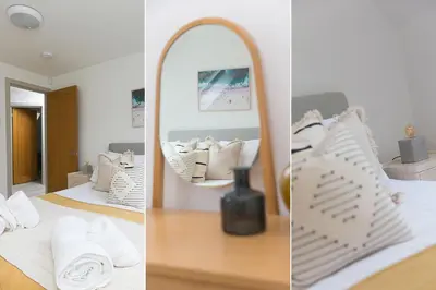 a bedroom with a mirror and a bed with white pillows at Westholme in St Ives