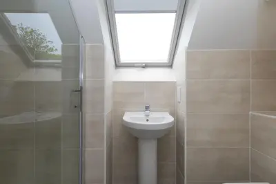 a bathroom with a sink and a shower with a skylight at Westholme in St Ives