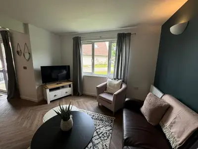 a living room with a couch and a table and a tv at 3 Bedroom lodge Hengar Manor sleeps 6 115 in Michaelstow
