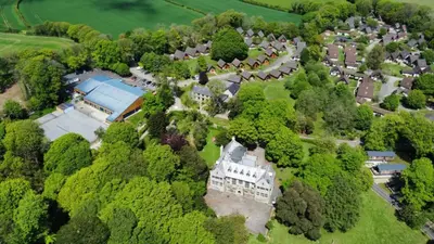 an aerial view of an old mansion in the trees at 3 Bedroom lodge Hengar Manor sleeps 6 115 in Michaelstow