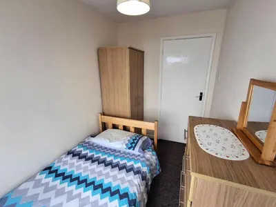 a small bedroom with a bed and a dresser at Loe Bar Top in Porthleven