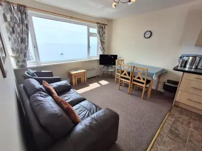 a living room with a leather couch and a table at Loe Bar Top in Porthleven
