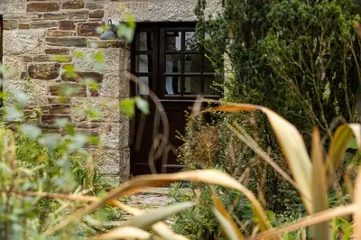 a wooden door in a brick building with plants at Nuthatch by Together Travel - Luxury Cornish Countryside Retreat in Bodmin