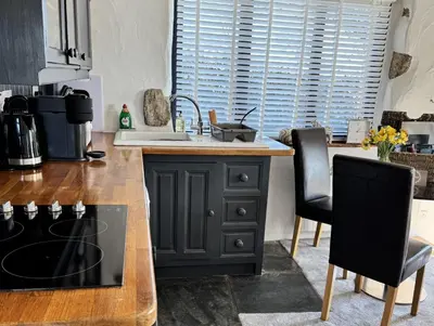 a kitchen with a counter with a stove top oven at Nuthatch by Together Travel - Luxury Cornish Countryside Retreat in Bodmin