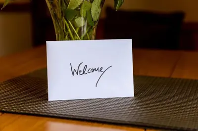 a white card sitting on a table with a vase at Tawnawood by Together Travel - Luxury Cornish Countryside Retreat in Bodmin