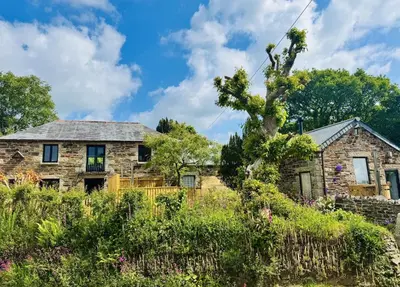 an old stone house with a garden in front of it at Tawnawood by Together Travel - Luxury Cornish Countryside Retreat in Bodmin