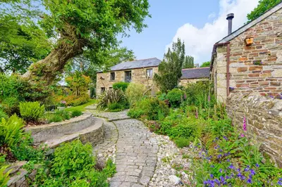 an old stone house with a garden in front of it at Tawnawood by Together Travel - Luxury Cornish Countryside Retreat in Bodmin