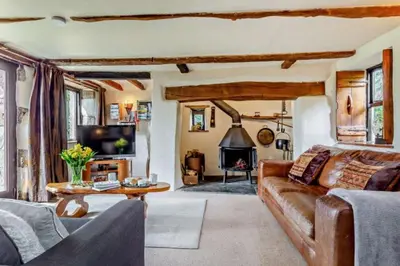 a living room with a couch and a fireplace at Tawnawood by Together Travel - Luxury Cornish Countryside Retreat in Bodmin