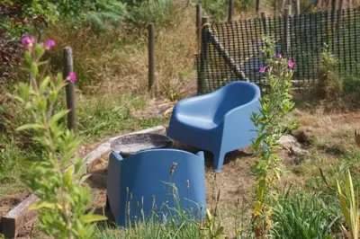 a blue chair sitting in a garden next to a plant at Glamping Meadow Bell Tent in Stithians