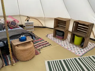 a bedroom with a tent with a bed and a fireplace at Glamping Meadow Bell Tent in Stithians