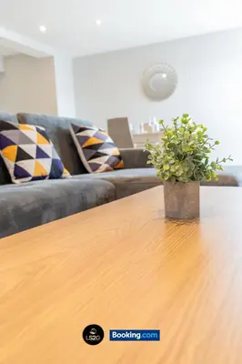 a potted plant sitting on top of a wooden table at Spacious 2 Bedroom Flat By LS2G Short Lets & Serviced Accommodation Greater London With Free WIFI in Newquay