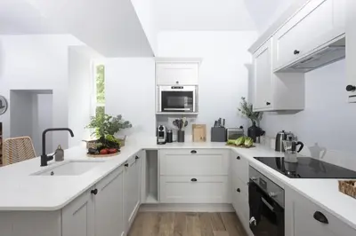 a white kitchen with white cabinets and a sink at The Elms in Uny Lelant