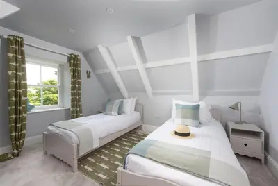 a bedroom with two beds and a window at The Elms in Uny Lelant