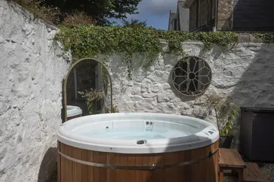 a bath tub in a yard with a stone wall at The Elms in Uny Lelant
