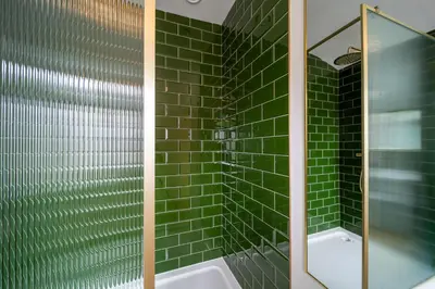 a green tiled bathroom with a shower and a tub at The Flat - Brand new renovation in amazing location in St. Agnes