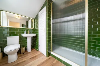 a bathroom with green tiles and a toilet and a sink at The Flat - Brand new renovation in amazing location in St. Agnes