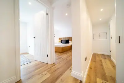 a bedroom with a bed and a hard wood floor at The Flat - Brand new renovation in amazing location in St. Agnes