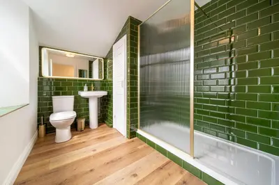 a bathroom with green subway tiles and a toilet at The Flat - Brand new renovation in amazing location in St. Agnes