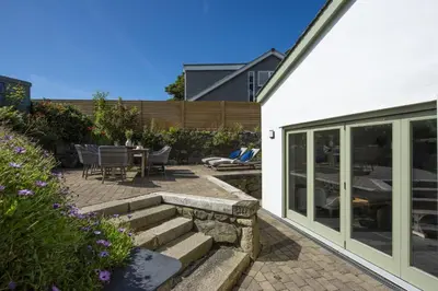 a patio with a table and chairs next to a house at Fairings, St Ives in St Ives